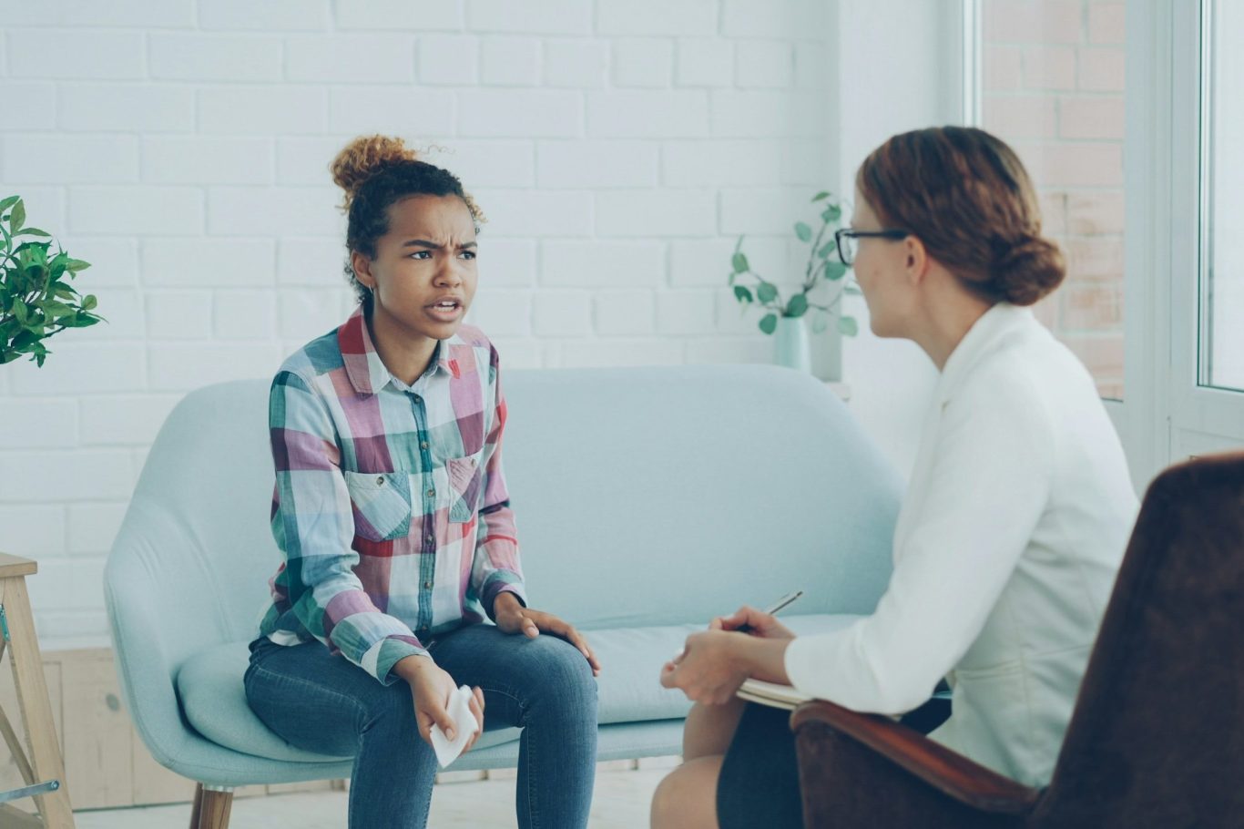 Two people in a supportive one-to-one conversation on a sofa